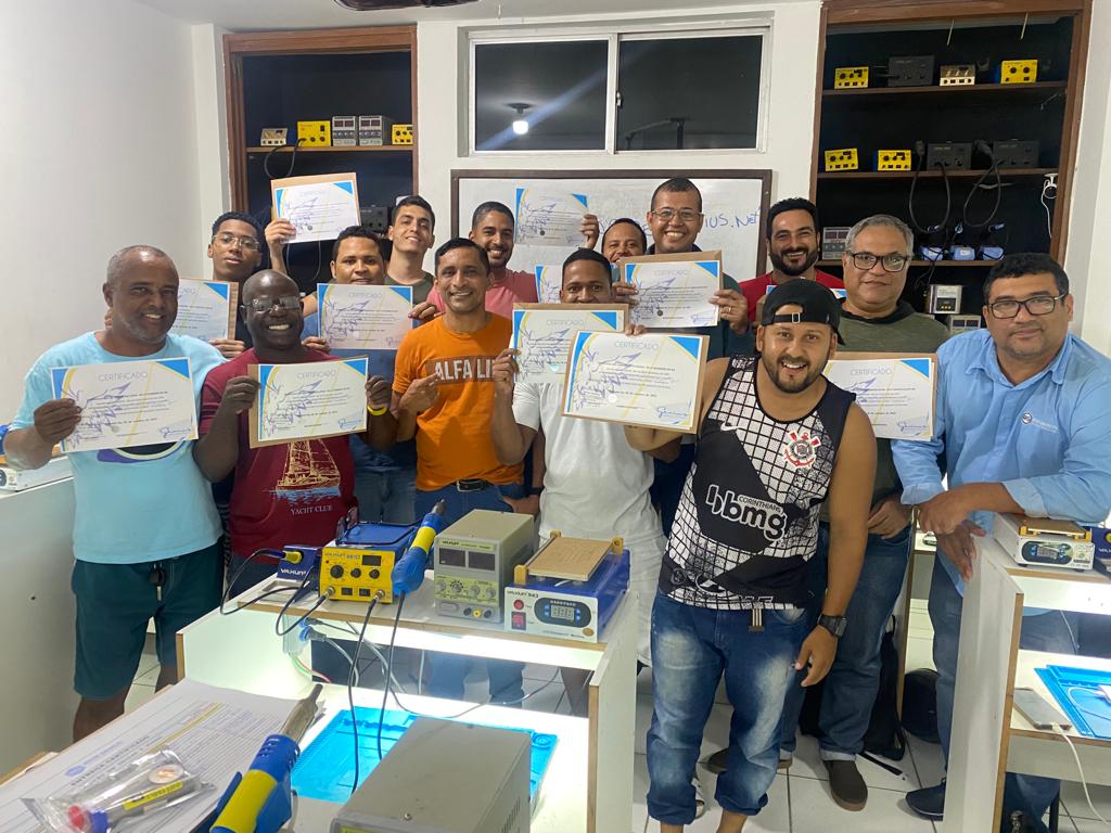 Alunos formados em manutenção de celular exibindo certificados — Rede Genius Bahia
